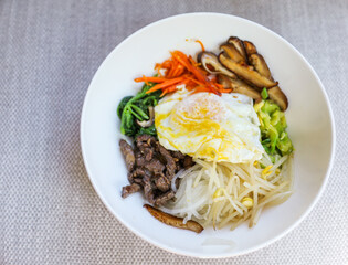 Vibrant and colorful bibimbap bowl filled with fresh and healthy vegetables, symbolizing a nutritious meal and the importance of a balanced diet for overall well-being