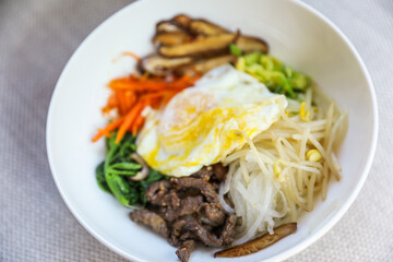 Vibrant and colorful bibimbap bowl filled with fresh and healthy vegetables, symbolizing a nutritious meal and the importance of a balanced diet for overall well-being
