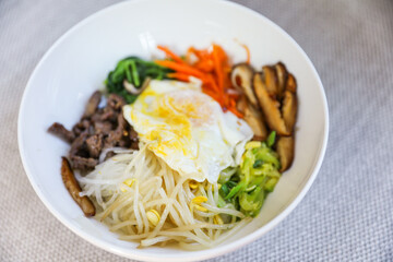 Vibrant and colorful bibimbap bowl filled with fresh and healthy vegetables, symbolizing a nutritious meal and the importance of a balanced diet for overall well-being
