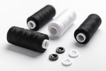 Set of thread spools and buttons on light background