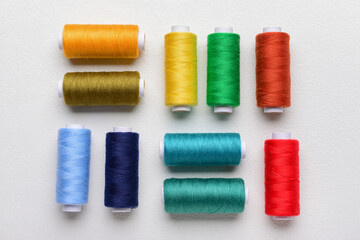 Composition with colorful thread spools on light background