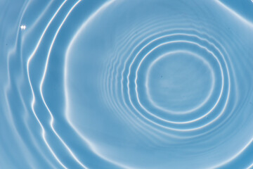 Blue water with ripples on the surface. Defocus blurred transparent blue colored clear calm water surface texture with splashes and bubbles. Water waves with shining pattern texture background texture