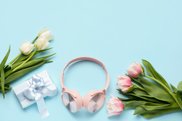 Obraz na płótnie Canvas Modern headphones, beautiful tulip flowers and gift box on color background