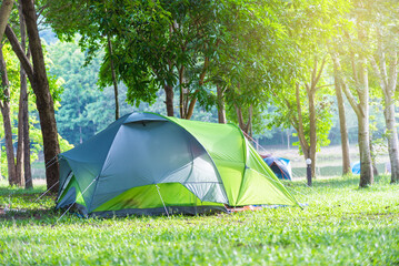Green camping tent on the lawn in the national park on a relaxing holiday