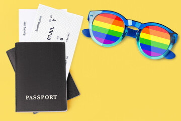 Black passport, airplane boarding pass, flight ticket, sunglasses LGBT community flag colors,...