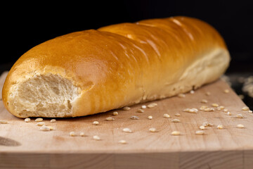 Wheat baguette on a wooden cutting board