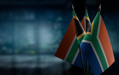 Small flags of the South Africa on an abstract blurry background