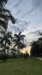 Fototapeta premium Building and trees on a sunset with a cloudy sky at Sudoeste neighborhood, Brasília, DF