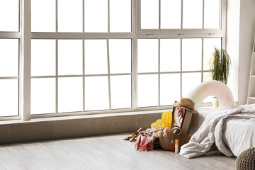 Open suitcase with beach accessories in bedroom