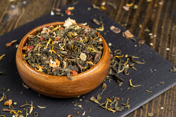 A large amount of dry green tea with pieces of fruit