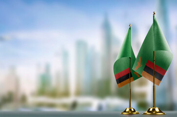 Small flags of the Zambia on an abstract blurry background