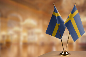 Small flags of the Sweden on an abstract blurry background