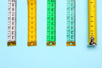 Colorful measuring tapes on blue background