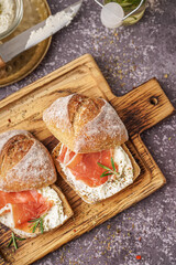 Fototapeta na wymiar Wooden board of tasty sandwiches with jamon on grey grunge background