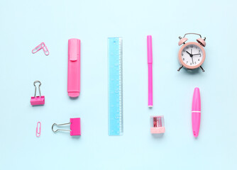 Clock and stationery supplies on blue background