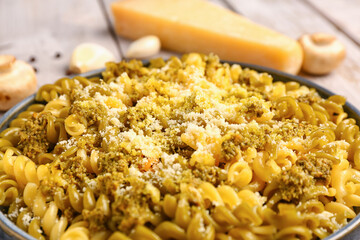 Plate of tasty Italian pasta with Parmesan cheese on table, closeup