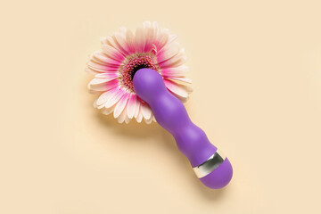 Vibrator with flower on beige background