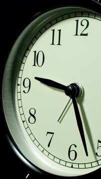 Vertical time lapse video of a clock time passing over a day to night.