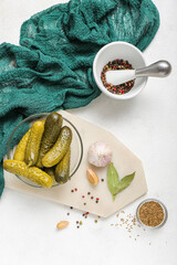 Bowl with tasty fermented cucumbers on light background