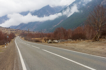 A deserted highway, a highway in a mountainous area panoramic view of the evening and low clouds.