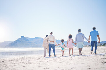Holding hands, back and big family at the beach for walking, holiday and summer weekend by the...