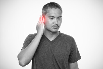 Man has sore ear. Isolated on gray background. Healthcare and health problem concept