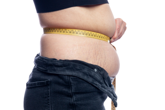 A woman with fat on her stomach measures the volume with a measuring tape. Overweight and diet. Without background.