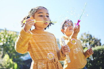 Playing, garden and children blowing bubbles for bonding, weekend activity and fun together. Recreation, outdoors and siblings with a bubble toy for leisure, childhood and enjoyment in summer - Powered by Adobe