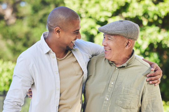 Love, father and adult son outdoor, hug and happiness with bonding, quality time and cheerful. Family, son and dad with a smile, embrace or loving together in nature, park or happy with care or relax