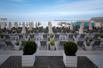 A deserted beach on the coast of Sochi with sun beds and umbrellas against the background of the...