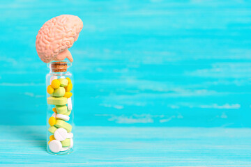 Human Brain Model on Top of a Small Glass Bottle of Pills