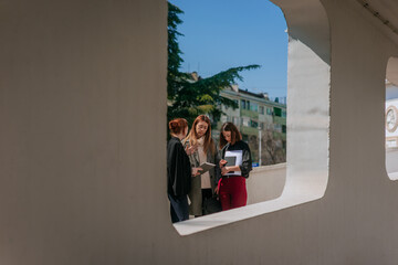 Ginger woman showing something on the tablet to her colleagues while working together outside