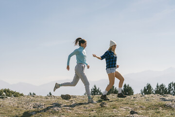 Two girls running in the mountains