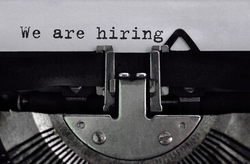 Text We are hiring typed on retro typewriter