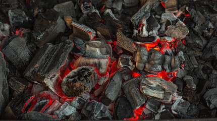 Burning charcoal for grilling close-up. Smoldering charcoal inside the grill gives heat for cooking pickled meat, barbecue, steak, vegetables, barbecue.