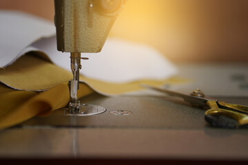 Sewing machine with scissors and brown fabric.     