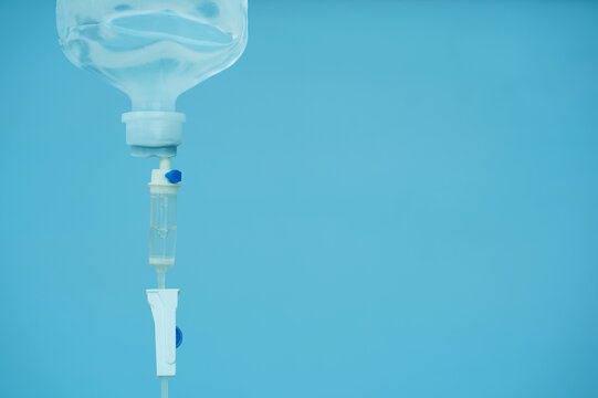 0.9% Normal saline solution (NSS) in the hospital. Close up drops of saline solution blue background.