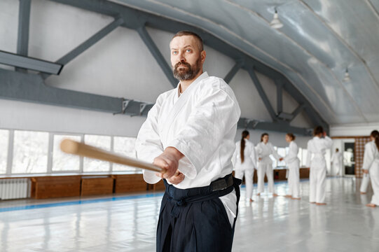 Aikido sensei master with wooden sword at group training