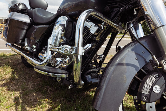black motorcycle side view close-up ,motorcycle standing on green grass isolated,close-up view