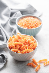 Red lentil fusilli pasta.  Bowl with raw pasta and red lentils. Gluten free pasta.