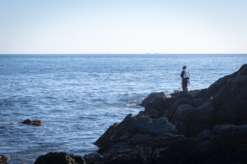 Fototapeta na wymiar 海で釣りをする人
