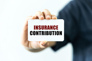 Insurance contribution text on blank business card being held by a woman's hand with blurred background. Business concept about insurance contribution.