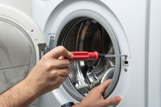 plumber fixing washing machine in bathroom, closeup