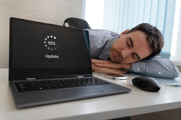 A new operating system update. software is in process of updating. The employee is tired and sleeps...