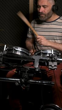 Man playing drums in a recording studio. Music production.