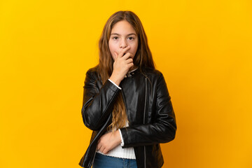Child over isolated yellow background surprised and shocked while looking right
