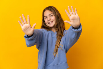 Child over isolated yellow background counting ten with fingers