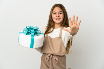 Little girl holding a big cake over isolated white background counting five with fingers