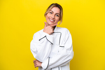 Uruguayan chef woman isolated on yellow background smiling