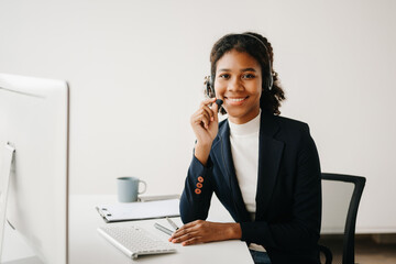 Serious call center operator in wireless headset talking with customer, woman in headphones with microphone consulting client on phone in customer support service in business center